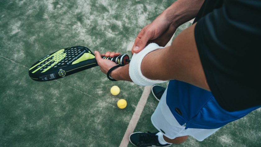 Joueurs de padel, raquettes en main, près du filet